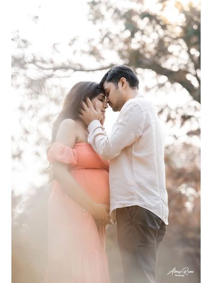 A soft, dreamy portrait of the couple sharing a quiet moment. The high-key lighting and gentle focus create a romantic and ethereal feel, perfect for a maternity photoshoot.