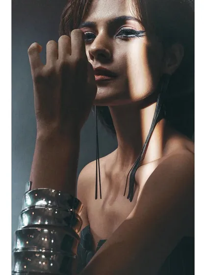 A close-up on the styling details from the Sigma shoot. The sharp winged eyeliner, long earrings, and metallic cuff are highlighted by the focused beam of light, showing my attention to every element of the look.