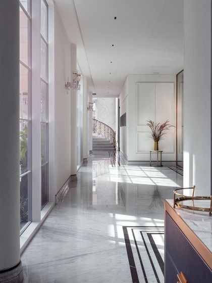 The long, sunlit corridors of The Grand Alabaster are designed to feel both grand and welcoming. The light reflecting off the polished marble floors, combined with views into the central courtyard, creates a bright and serene pathway through the home.
