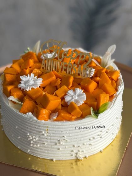 Another look at my custom Chocolate Mango Cake, topped with a "Happy Anniversary" sign. The combination of rich chocolate and sweet mango is a delightful surprise.