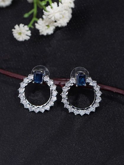Blue and silver hoop earrings styled on a dark surface. The simple, clean composition is perfect for catalogue and website use.