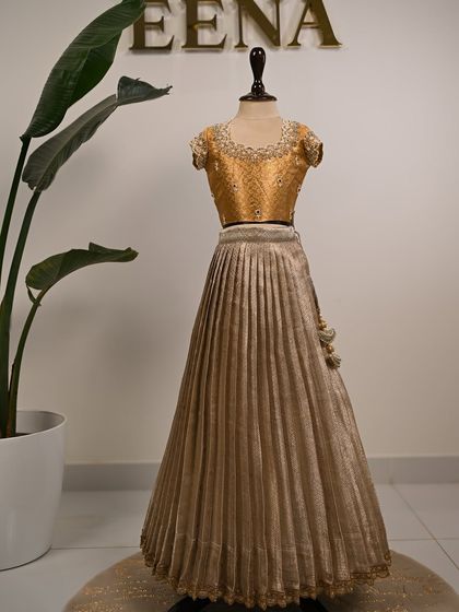 My super energetic baby client Smaya looks absolutely adorable in her customized tissue lehenga. I designed this golden outfit with a beautiful hand-embroidered blouse featuring pearl and stone work around the neckline.