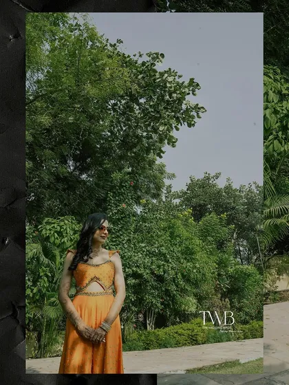 A wide shot of the bride against a backdrop of lush greenery. This photo captures the beauty of the natural surroundings at her destination haldi ceremony.