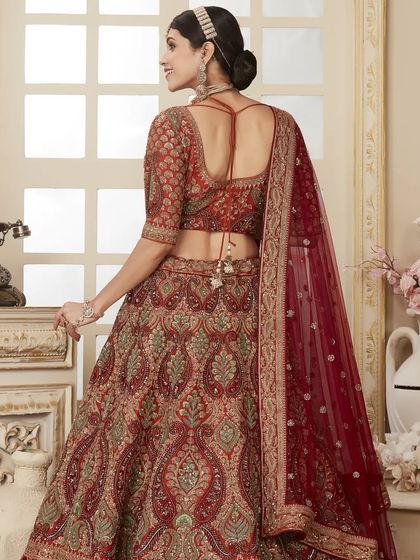 A view of the stunning back design and intricate details of a maroon bridal lehenga. The deep-back blouse and elegant tassels add a touch of modern allure.