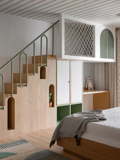 This playful kids' bedroom features a custom-built loft bed with a staircase that includes unique storage nooks. The green metal railing and reeded cabinet doors add color and texture.