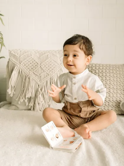 A one-year-old boy's expressions are priceless. Here he is, looking so animated while "reading" a book.