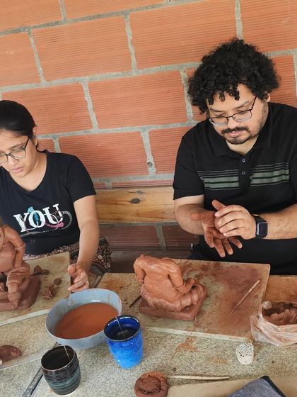 A couple works together, each sculpting their own Ganesha idol. It's a wonderful activity to share with a loved one during the festive season.