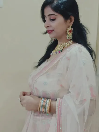 A side profile showing the beautiful jewelry paired with the pink and silver lehenga.