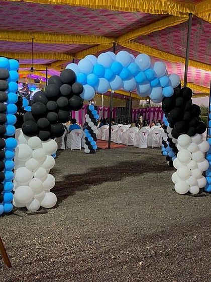 The entrance to a Boss Baby party, with a welcome sign and a balloon arch in the theme's signature blue, black, and white colors.