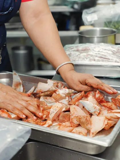 This is where the flavour begins, with my own hands. I believe in the power of touch to create and elevate, whether it's marinating fresh fish or mixing spices. This commitment to the handmade process is what makes every product from my kitchen a true homestyle experience.