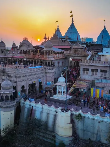 A close-up aerial view of the main temple in Barsana during sunset. The intricate details of the architecture are highlighted by the warm light.