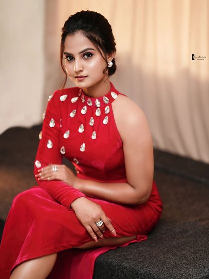 A seated portrait of Thanvi, looking elegant and poised. The makeup is sophisticated and timeless.
