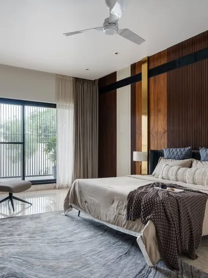 This serene bedroom in the Celadon project is designed as a personal retreat. A palette of natural wood, warm metals, and soft textiles, combined with large windows framing garden views, creates a space of ultimate comfort and tranquility.