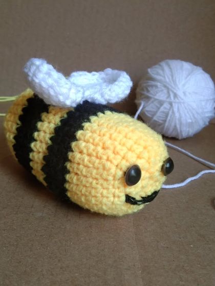 The baby bee amigurumi, a smaller and chubbier version of the mommy bee. It's a cute little prop that can easily fit into a photoshoot setup.