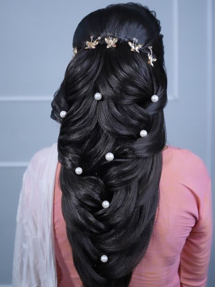 This mermaid braid features large pearls and a golden butterfly hair vine, creating a whimsical and enchanting look.