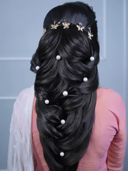 This mermaid braid features large pearls and a golden butterfly hair vine, creating a whimsical and enchanting look.
