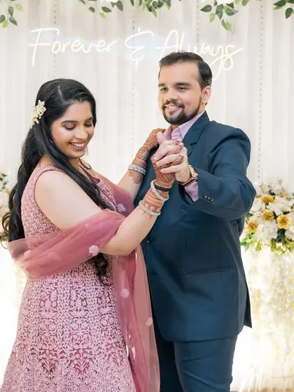 A happy couple dancing at their reception, with a 'Forever & Always' sign in the background.