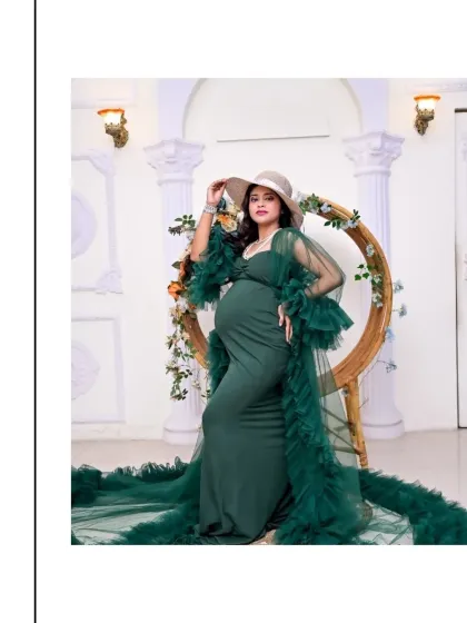 A stylish portrait showing off our popular green tulle gown. The addition of a wide-brimmed hat adds a touch of modern glamour to this classic maternity look.