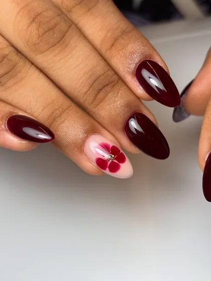 Sometimes, elegance is everything. This design pairs a deep, glossy berry red with a delicate, hand-painted flower accent nail, creating a look that's both classic and sophisticated.