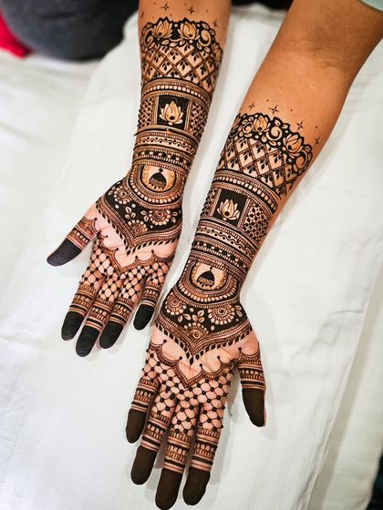 A symmetrical design for both arms, featuring lotus motifs and architectural domes. The dark, solid fingertips are a classic bridal choice.