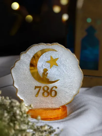 A beautiful resin art piece with a crescent moon and star, styled with warm fairy lights in the background to create a magical and festive ambiance.