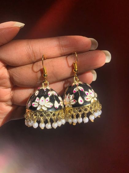 A classic Meenakari hook earring in black and white. The floral painting and pearl details make this a timeless piece that never goes out of style.