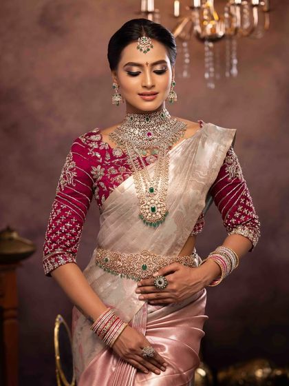 The full view of this elegant bridal look, showing the intricate embroidery on the blouse and the perfectly draped saree. The makeup is designed to photograph beautifully from every angle.
