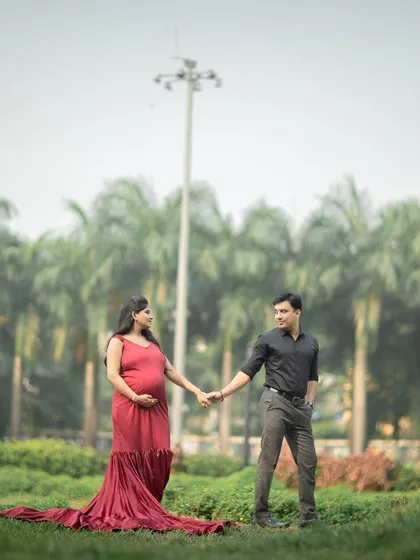 A full-length portrait of the couple in a beautiful park, holding hands and sharing a look of love.