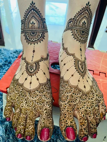 Mehendi for feet can be both simple and beautiful. This design combines delicate chains and paisleys with scalloped patterns on the toes for an elegant bridal look.