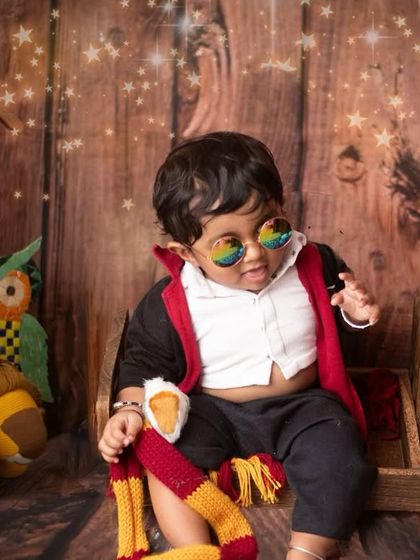 Born with a little bit of Hogwarts magic. The cool sunglasses and Gryffindor scarf complete this magical look. Themed baby photography is all about creativity and fun.