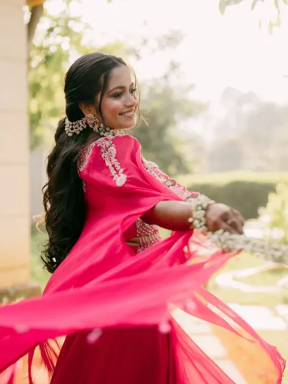 A Haldi ceremony is all about joy and vibrancy. This bride is twirling with happiness, and her fresh makeup look with floral jewelry was designed to match that bright, playful energy.