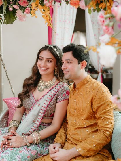 Seated on a beautifully decorated swing, this couple looks picture-perfect at their Mehendi. The bride's makeup is kept fresh and luminous to match the vibrant, floral decor.