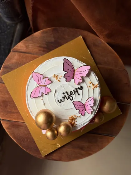 A beautiful cake for your "wifey," decorated with pink butterflies and golden spheres. It's a chic and modern way to show your love.