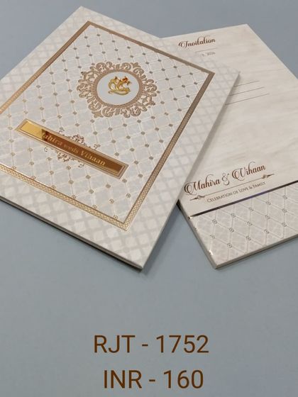 This elegant cream-colored invitation features a Ganesha emblem inside a patterned border. The design is classic and understated, suitable for a formal ceremony.