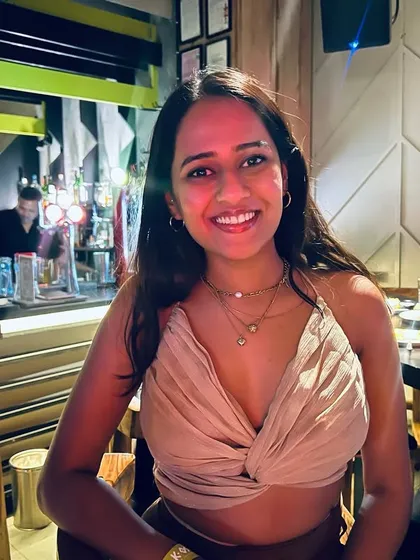 A guest looking radiant and happy, enjoying the vibrant atmosphere of our packed gamebar.
