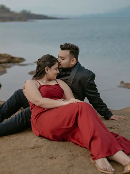 A gentle forehead kiss, a classic romantic gesture captured beautifully against the serene lakeside backdrop.