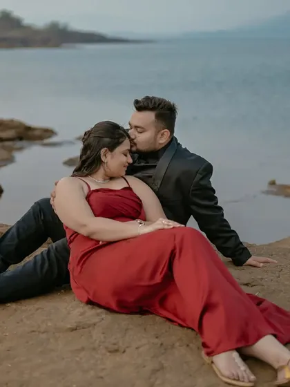 A gentle forehead kiss, a classic romantic gesture captured beautifully against the serene lakeside backdrop.