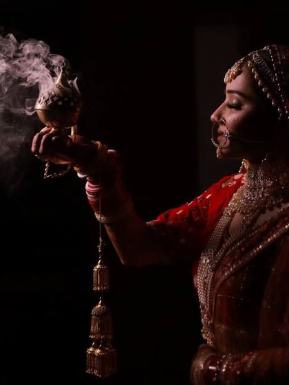 A creative and atmospheric shot of the bride. The dramatic lighting highlights her profile and the intricate details of her look.