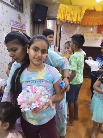 Another happy student showcasing her colorful tissue paper flower. These craft sessions are always full of laughter and creativity.