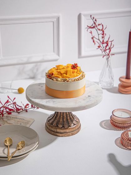 Our supreme mango cake, elegantly presented on a marble cake stand. Don't trust us? Try it and decide for yourself!