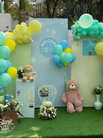 The main backdrop for the baby shower, with balloon arches in pastel shades, teddy bears, and floral arrangements creating a sweet and charming photo spot.