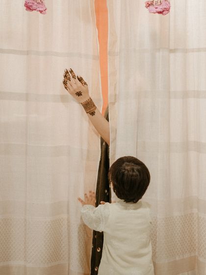 A playful and tender moment between the bride and a child during the at-home mehendi. These candid shots capture the real, unscripted essence of a family celebration.