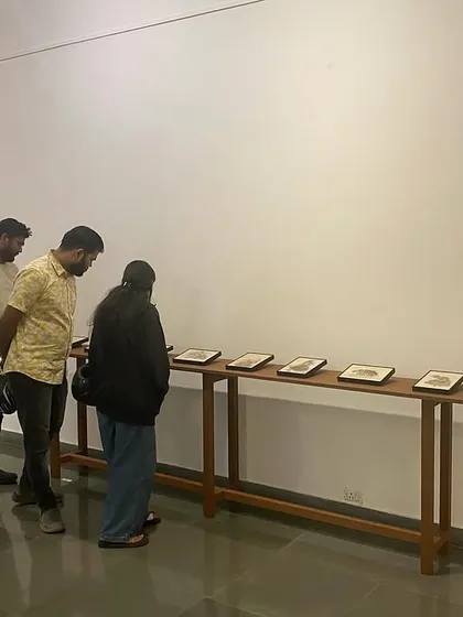 A group of young visitors studying the intricate details of Shakuntala Kulkarni's work.