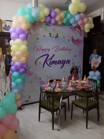 A dreamy unicorn theme backdrop for a small home party. The pastel balloon garland and unicorn cutout create a magical setting for the birthday girl and her friends.