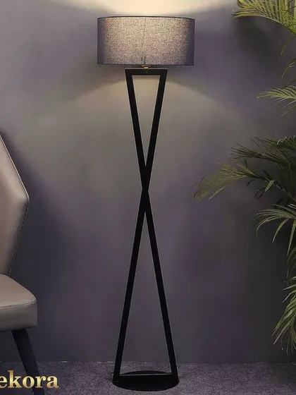 For a touch of modern minimalism, this floor lamp features a striking black metal base with an intersecting design. Topped with a simple grey shade, it provides focused, stylish lighting without taking up visual space.