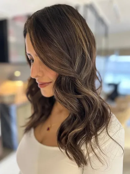 A dreamy beige balayage on a mid-length cut. The soft waves and beautiful color create a romantic and sophisticated style.