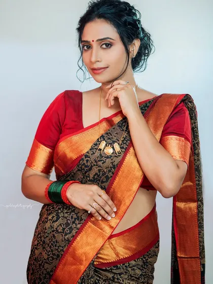 A classic portrait against a simple background, allowing the bride's personality and the beauty of the traditional saree to be the main focus.