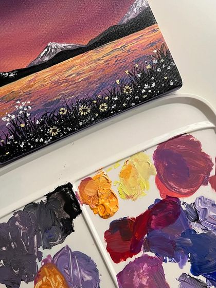 The rainbow sky painting next to the palette of colors I used to create the magical scene.