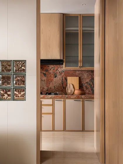 A peek into the kitchen from the main living area. The use of glass blocks on the dividing wall allows light to pass through, making the kitchen feel bright and connected to the rest of the home.