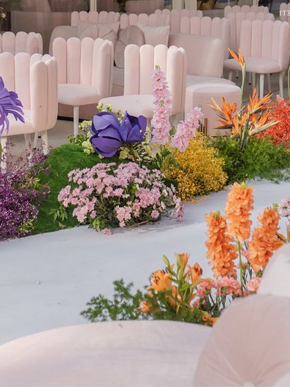 The floral-lined aisle is a rainbow of colors and textures, mixing different types of flowers for a wild and beautiful look.